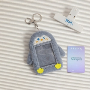 Detail showing plush penguin card holder with transparent window and metal keyring