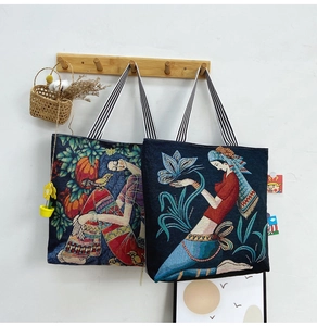 Ethnic woven tote bags with pumpkin and butterfly folk art prints on wooden rack