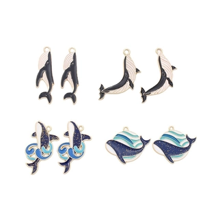 Eight enamel whale charm pendants in black blue and white with gold metal frames