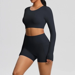 Zijaanzicht van zwarte crop top met lange mouwen en high-waist sportshort met strakke naden