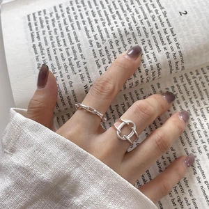 Close-up of minimalist 925 sterling silver chain and knot rings worn on finger