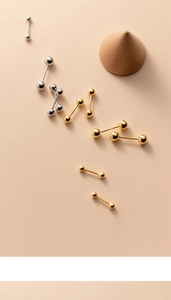 Vue détaillée de boucles d'oreilles boules en argent s925 et or sur fond beige uni
