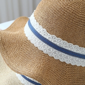 Women's wide brim straw sun hat featuring a lace ribbon and stylish blue denim bow detail