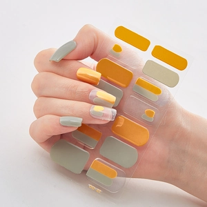 Detailed macro view of 3D laser gold nail stickers in mustard yellow and grey on white