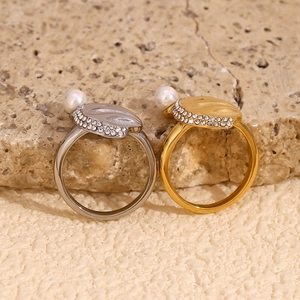 Macro detail of 18K gold and silver rings with shell pearls and paved zircons