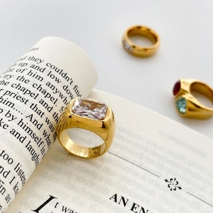 Macro shot of 18K gold plated square zircon ring on a book, showcasing luxury craft