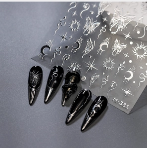 Macro view of silver 3D metallic gothic butterfly and snake nail art stickers on black tips
