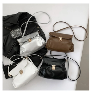 Detail shot of pleated crossbody bags in silver, brown, white, and black with metal locks