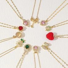 Flat lay of diverse gold layered necklaces featuring colorful heart and gemstone pendants