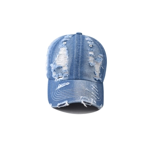 Detailed macro view of distressed denim fabric and ripped texture on blue baseball cap