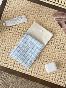 Blue and white checkered fabric storage bag with secure metal snap button and brand label