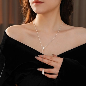 Close-up of silver water drop pendant necklace on model with Y-shaped minimalist chain