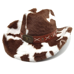Close-up of fluffy cow print cowboy hat with brown leather band and bull head emblem