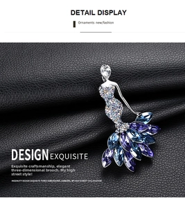 Detailed macro view of a crystal ballerina brooch with blue marquise-cut stones on dark leather