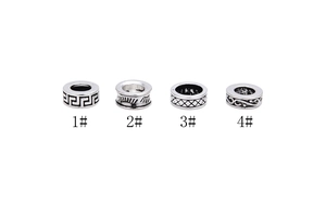 Detailed macro view of four S925 sterling silver spacer beads with vintage embossed patterns