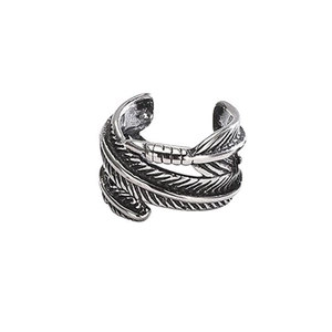 Macro detail of vintage silver feather earring featuring intricate textured engraving