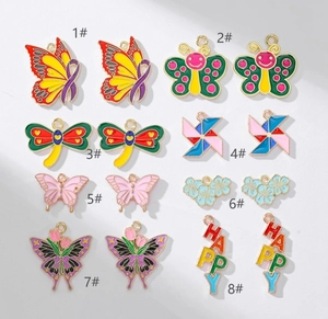 Macro shot of 8 assorted enamel butterfly and flower charms with HAPPY text for DIY jewelry