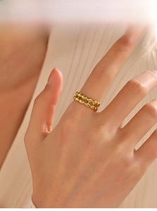 Detail showing two rows of gold-plated beads on an adjustable stainless steel ring