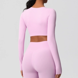 Vue arrière d'un ensemble crop top de yoga rose à manches longues et legging serré
