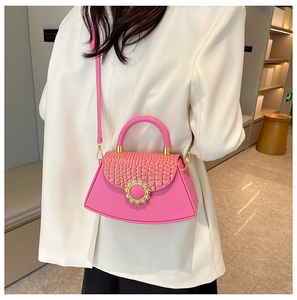 Details der rosa Handtasche mit Krokostruktur, goldener Sonnenblumenschließe und Bogenboden