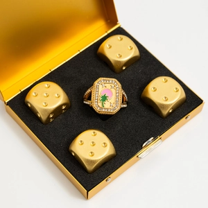 Détail de la bague en émail doré avec motif de palmier rose et vert dans son coffret