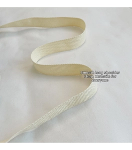Detail of cream woven shoulder strap showing thick twill pattern and soft texture