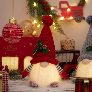 Detail of a glowing Christmas gnome with a red knit hat and warm white LED beard lights