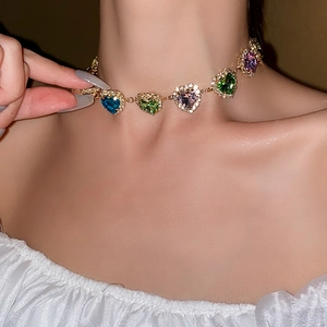 Detail of a gold choker featuring colorful heart gemstones worn by a model
