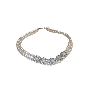 Double-layer silver necklace featuring pearl and diamond flower charms on white background