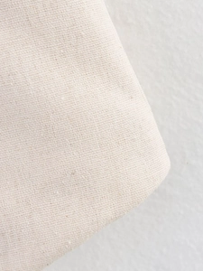 Detailed macro view of the natural beige linen fabric texture on sleeveless vest set