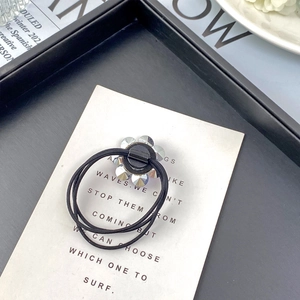 Close-up of a black elastic hair tie featuring a transparent K9 crystal flower charm