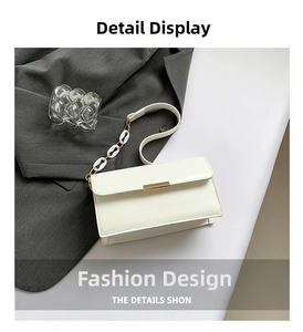 Detail of white glossy leather handbag with gold metal clasp and buckle shoulder strap