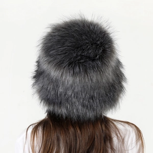 Dettaglio della folta trama in finta pelliccia sfumata nero-grigio su un cappello invernale