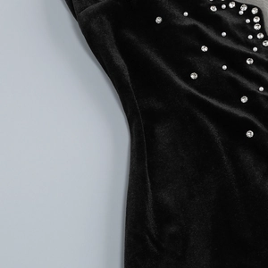 Detailed macro view of black velvet fabric with premium pearl and rhinestone embellishments