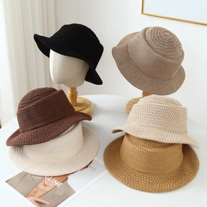 Breathable woven bucket hat for women in five assorted colors on a wooden display stand
