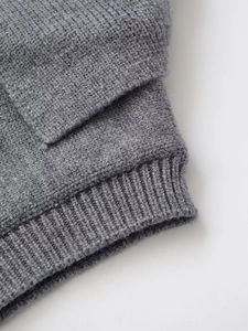 Dettaglio macro della trama in maglia grigia e del polsino a coste della maglia stile polo