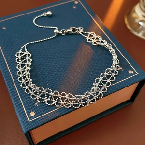 Detail view of silver lace-style hollowed metal bracelet with adjustable slide beads