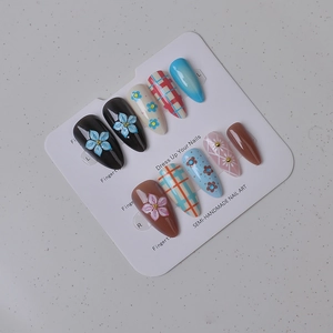 Detail view of semi-handmade press-on nails featuring 3D flowers and blue plaid patterns