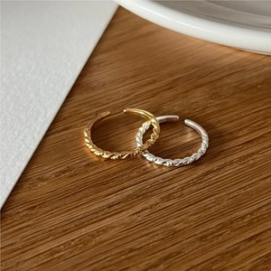 Close-up of minimalist S925 sterling silver twisted rope rings in gold and silver finish