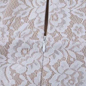 Close-up of white floral lace fabric and invisible zipper on a long dress lining