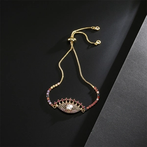 Détail macro du bracelet œil maléfique avec zircons colorés et chaîne dorée ajustable