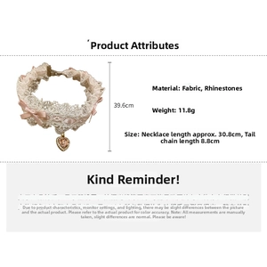 Detailed view of lace choker with pink bow and rhinestone heart pendant on white background