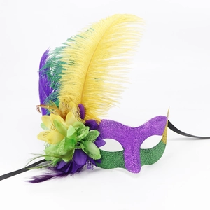 Detail of masquerade mask featuring purple glitter, yellow feathers, and floral accents