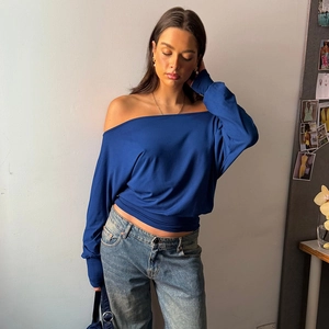 Detail of navy blue off-shoulder long sleeve top with slim fit and ribbed texture