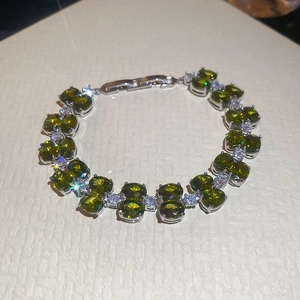 Detailed macro view of olive green oval zircon stones and silver clasp on the bracelet