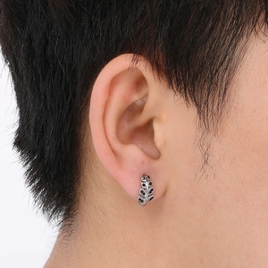 Close-up of men's titanium steel leaf earring with black stone on male model's ear