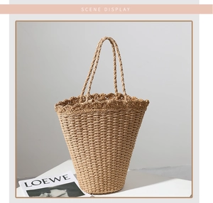 Detailed view of hand-woven straw beach bag with scalloped edge and sturdy handles