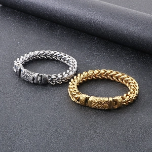 Detail of silver and gold dragon bone chain bracelets with vintage engraved clasps