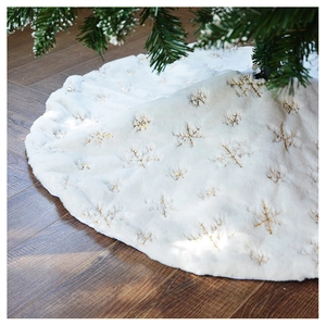 Close-up of white plush Christmas tree skirt featuring golden sequin snowflake patterns