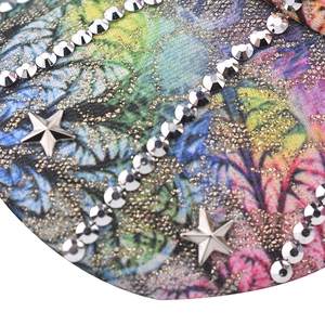 Macro shot of colorful printed fabric with rhinestones and silver star-shaped metal studs